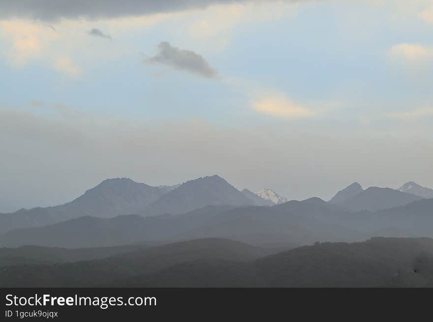 Mountains of Trans-Ili Alatau on an early cloudy morning in the morning fog during sunrise