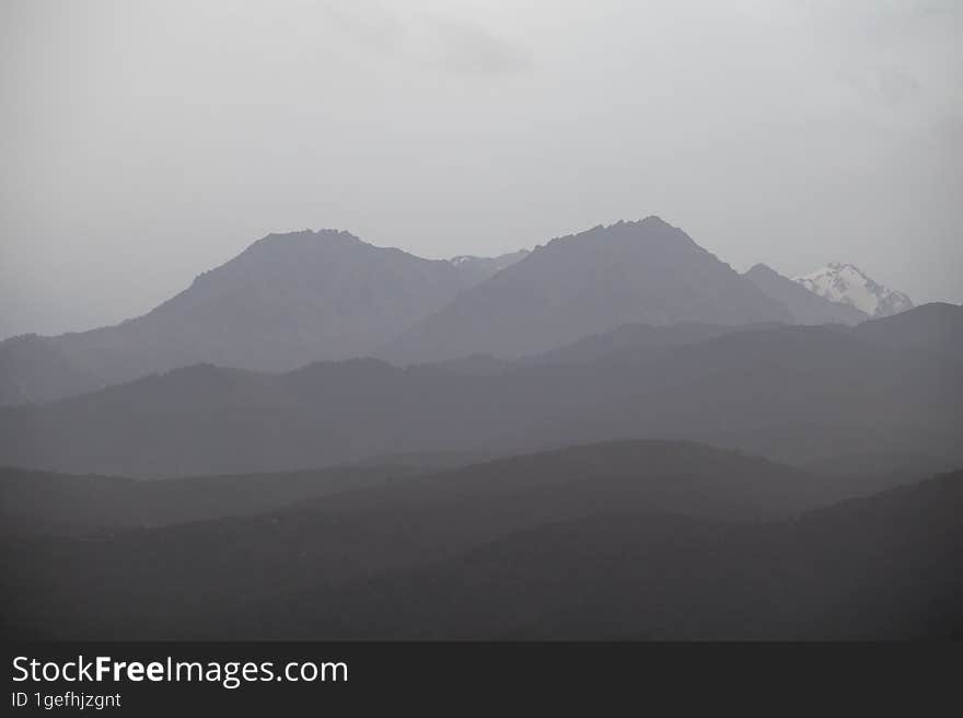 Landscape of the Trans-Ili Alatau mountains on an early cloudy morning in the morning fog