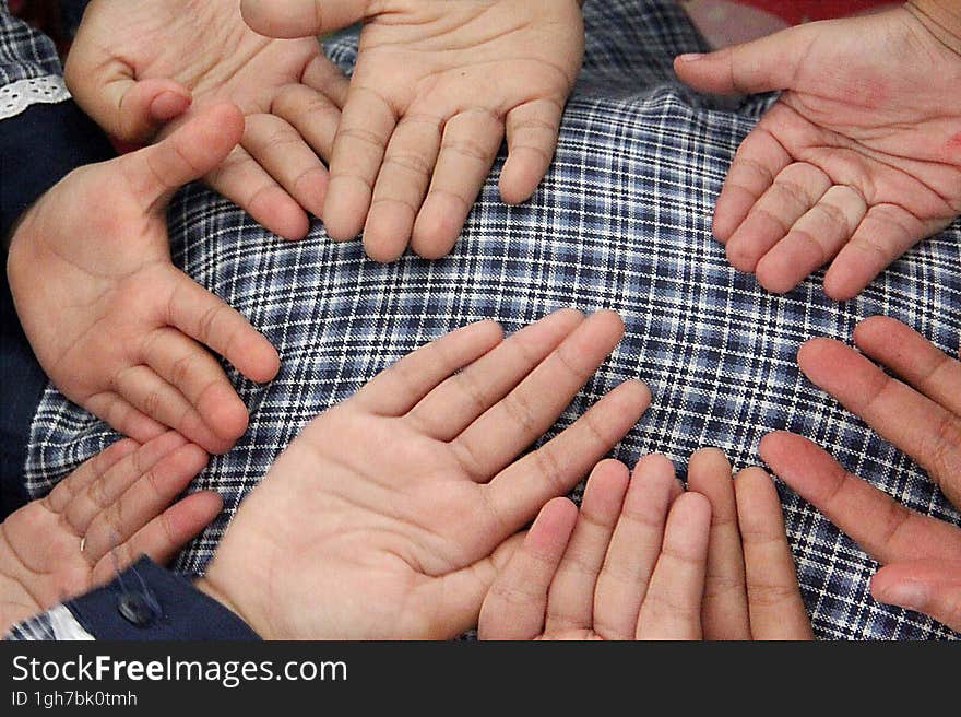 Small childrens palms, on a checkered cloth background.