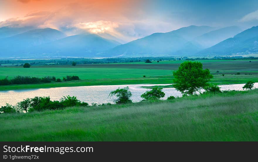 Summer Green Landscape.Beautiful Nature Background.Artistic Wallpaper.Art Photography.Sky, clouds, sun.Sunset,mountain,field.