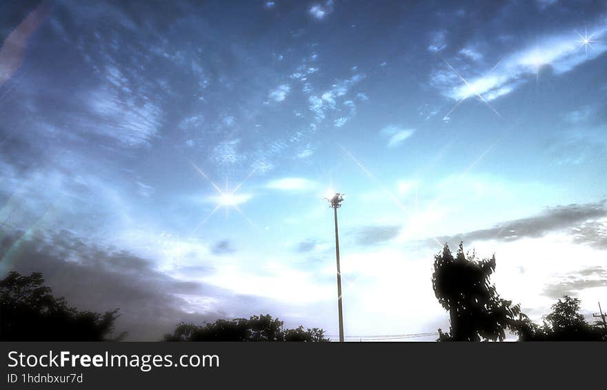 Clear Sparkle Twilight Sky With Light Tower And Tree Peaks, Slightly Clouds