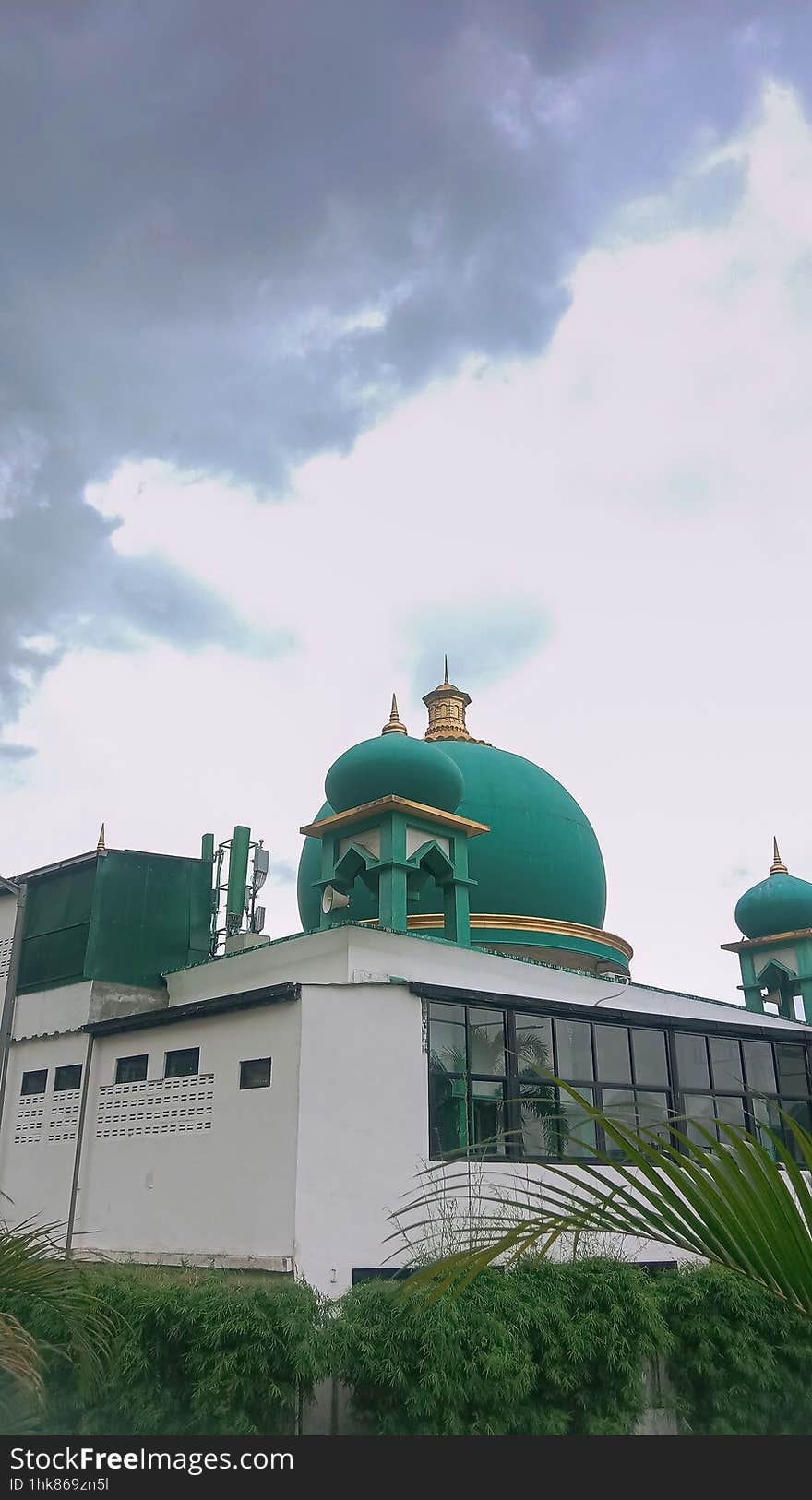 Nestled beneath Indonesia's expansive cloudy sky, a mosque stands as a serene testament to faith, its minarets reaching towards the heavens amidst the shifting clouds, embodying tranquility and spiritual devotion against the atmospheric backdrop. Nestled beneath Indonesia's expansive cloudy sky, a mosque stands as a serene testament to faith, its minarets reaching towards the heavens amidst the shifting clouds, embodying tranquility and spiritual devotion against the atmospheric backdrop.