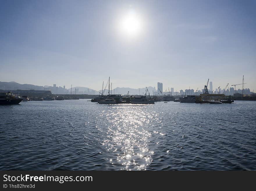 Marina of modern motors and yachts in sunshine, blue water harbor with bright sun shines