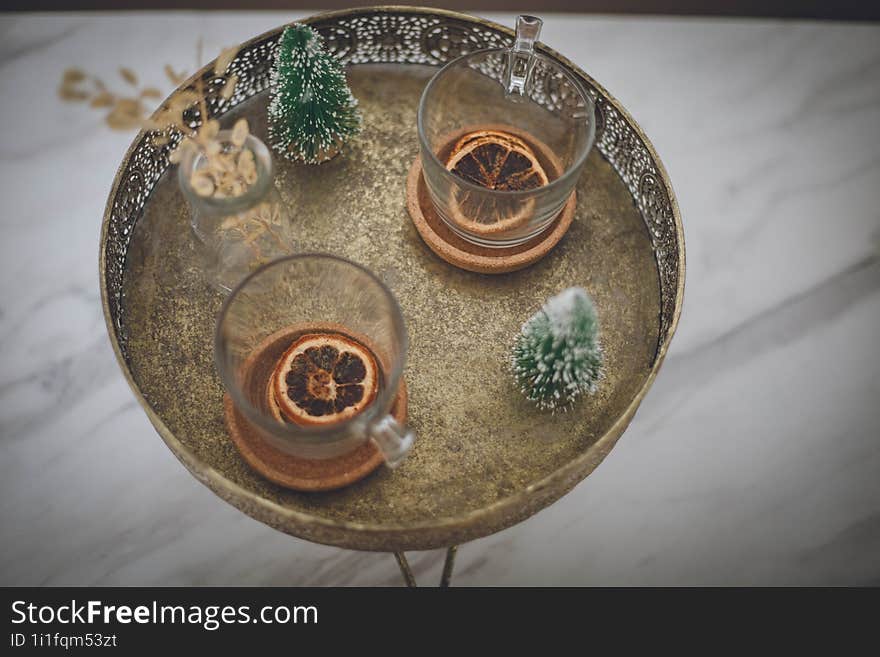 A small coffee table with tea cups and a piece of citrus