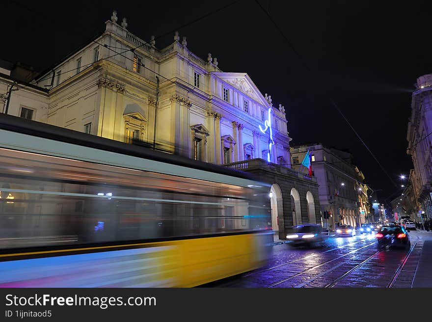 la scala theatre and street car by night in milan city in italy