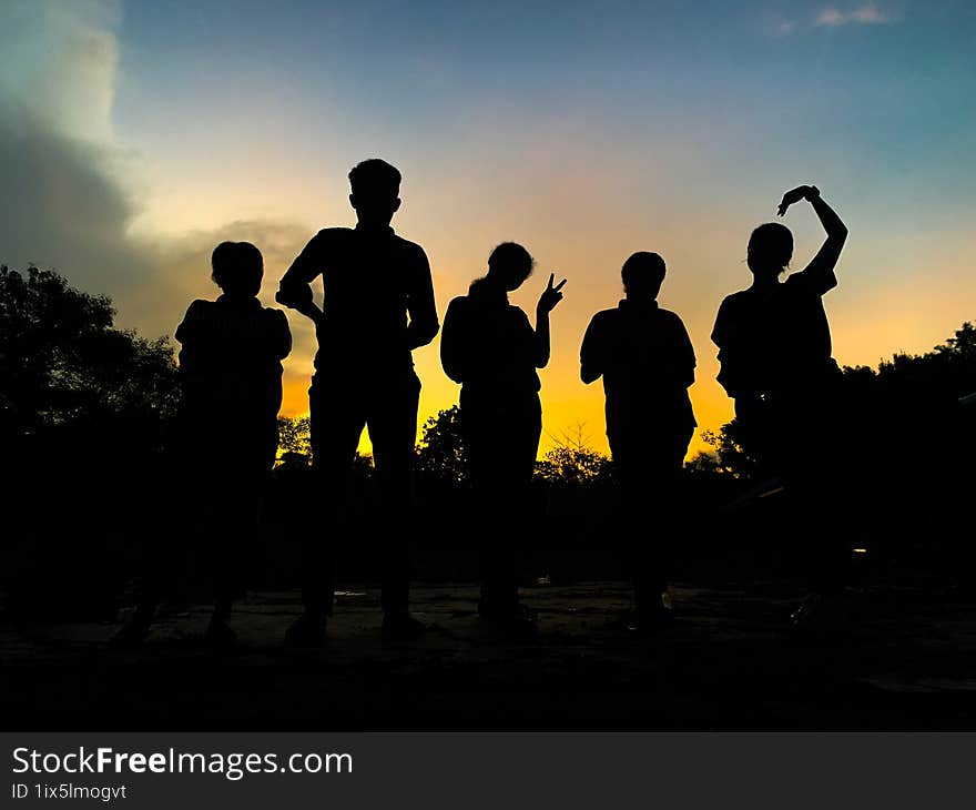 Silhouette Of A Group Of People In The Twilight Sky