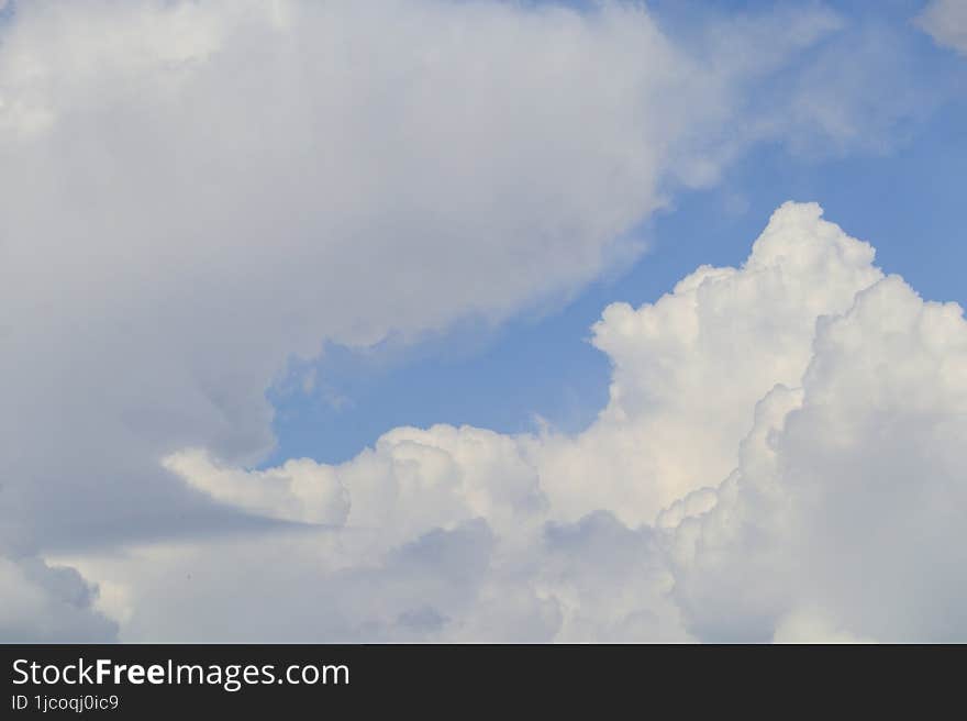 White large voluminous and gray cumulus clouds in the blue sky on a spring day