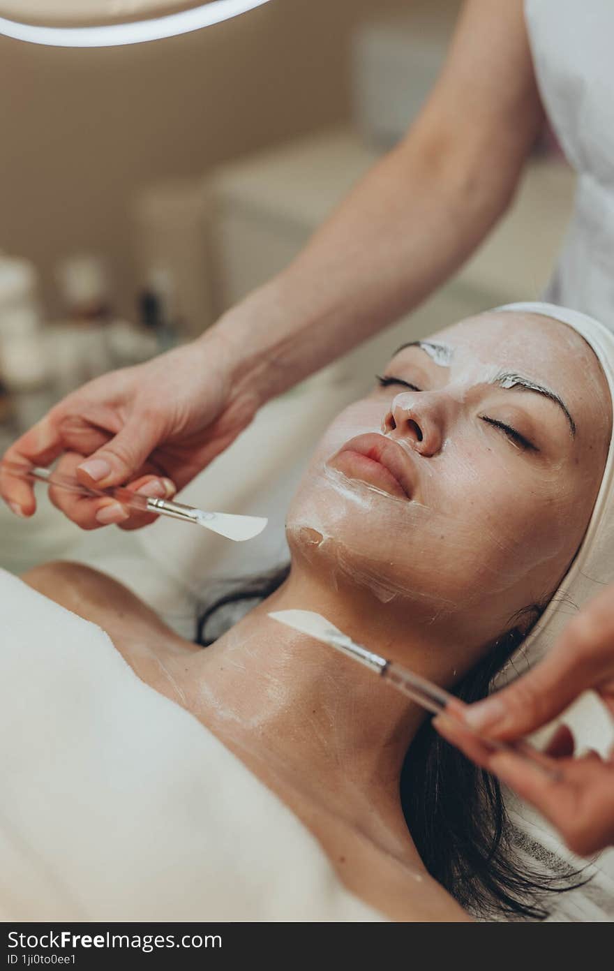 a young girl makes a face mask at a cosmetologist in a beauty salon. a young girl makes a face mask at a cosmetologist in a beauty salon