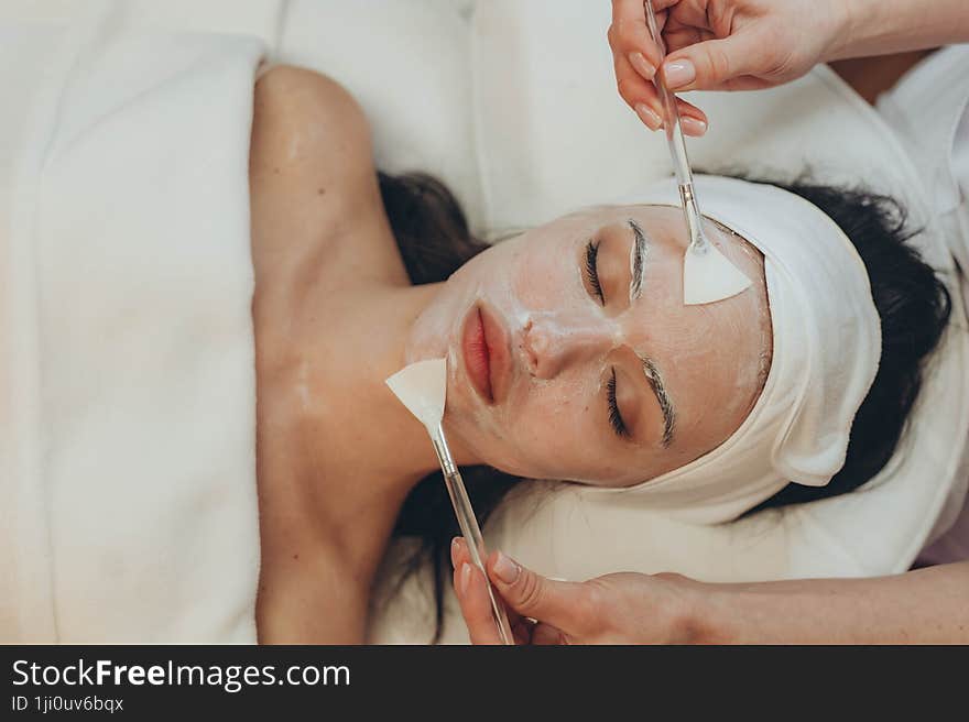 a young girl makes a face mask at a cosmetologist in a beauty salon. a young girl makes a face mask at a cosmetologist in a beauty salon