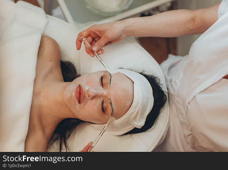 a young girl makes a face mask at a cosmetologist in a beauty salon. a young girl makes a face mask at a cosmetologist in a beauty salon