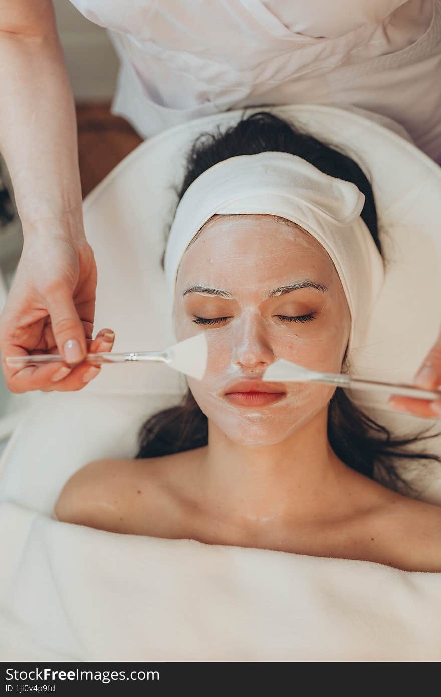 a young girl makes a face mask at a cosmetologist in a beauty salon. a young girl makes a face mask at a cosmetologist in a beauty salon