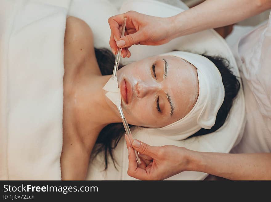 a young girl makes a face mask at a cosmetologist in a beauty salon. a young girl makes a face mask at a cosmetologist in a beauty salon