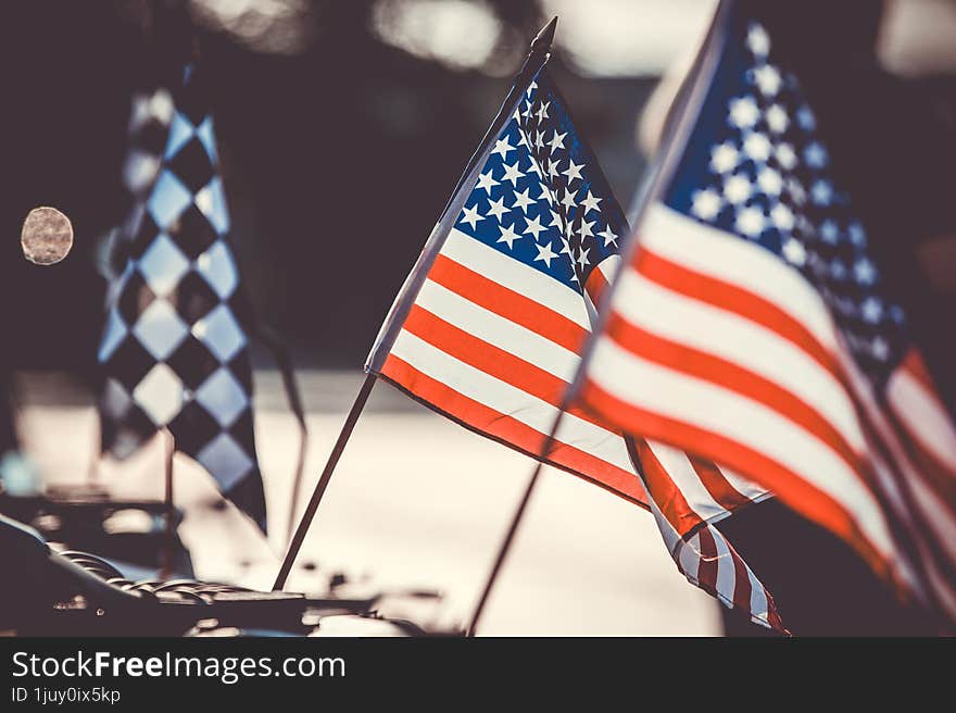 Small American flags and checkered flag flying against evening light