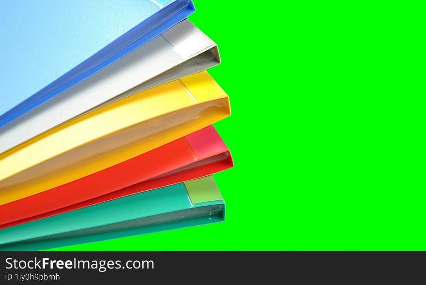 Stack of colorful folders on a green background