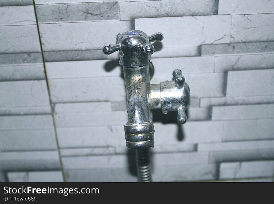 A faucet that has 2 nozzles and is installed in the bathroom.