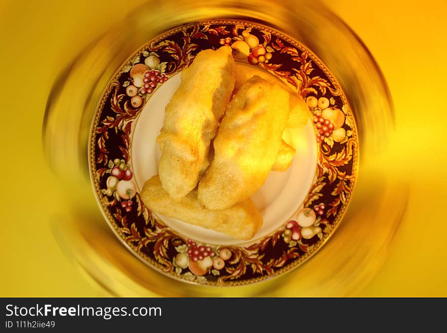 Serving Of Fried Bananas On A Small Plate With 5 Unpeeled Bananas Around It.