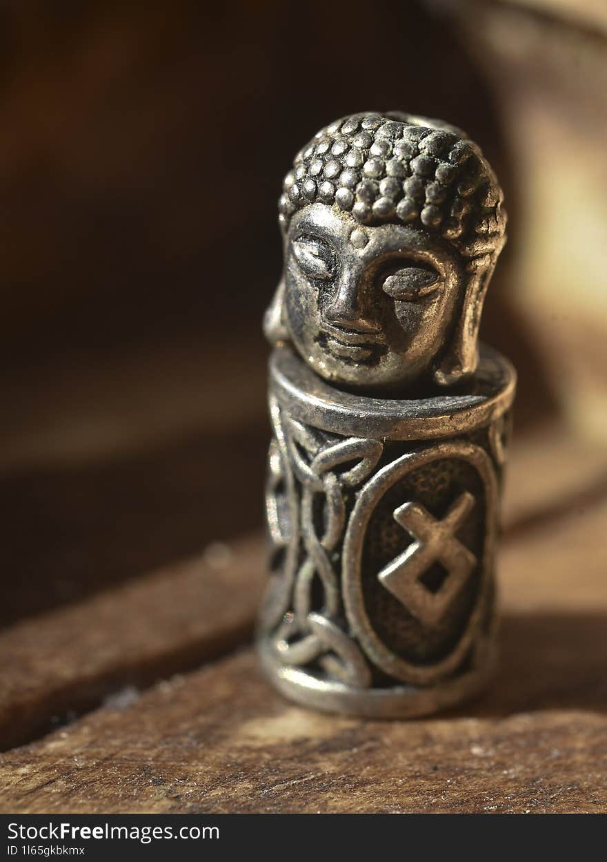 A metal budda head on a Viking rune