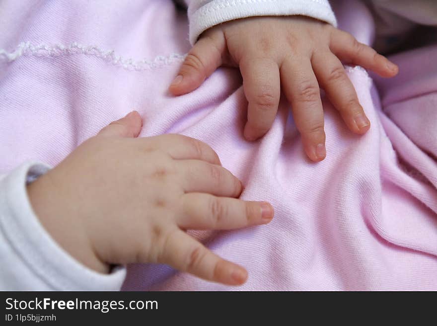 Small baby hands on pink backpack