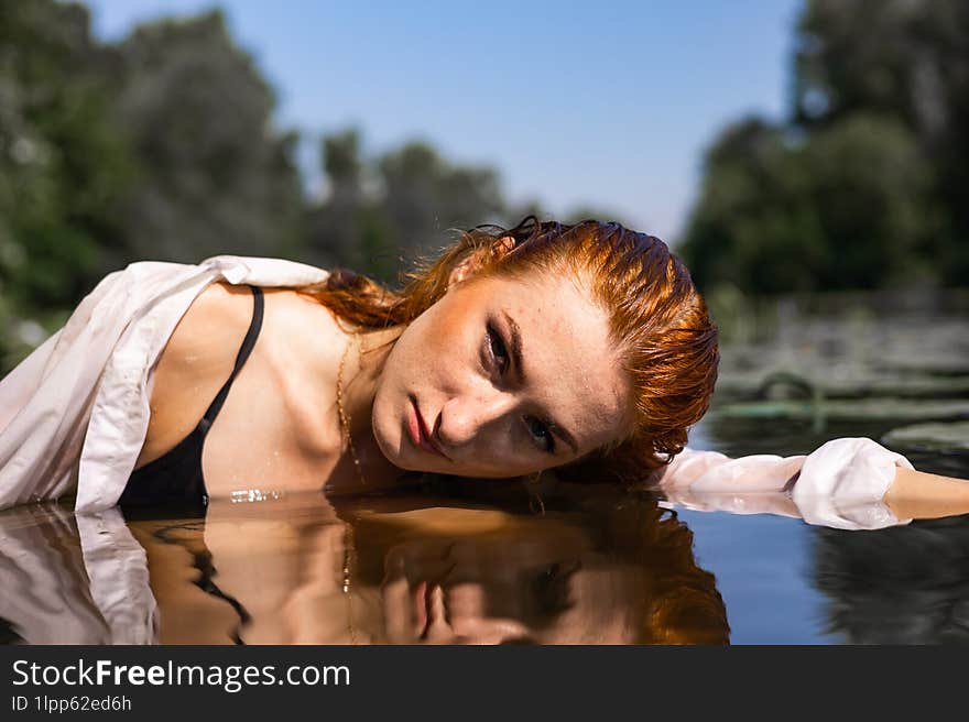 Red Hair Woman Swimming In Summer Lake With Lily