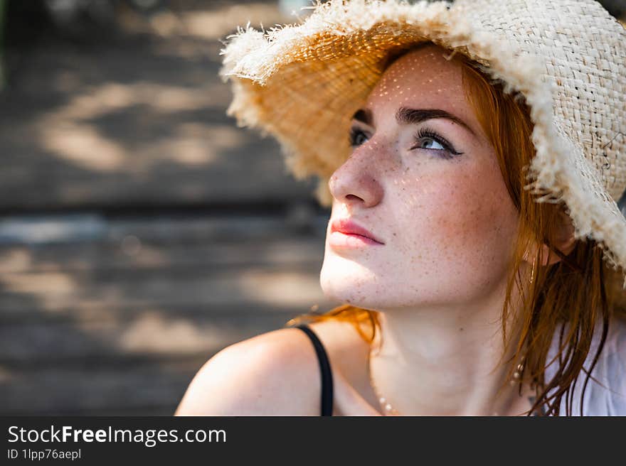 Red hair woman in swimsuit and summer hat near river.