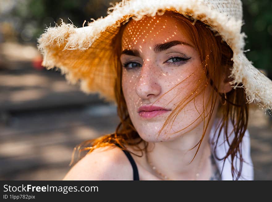 Red hair woman in swimsuit and summer hat near river.