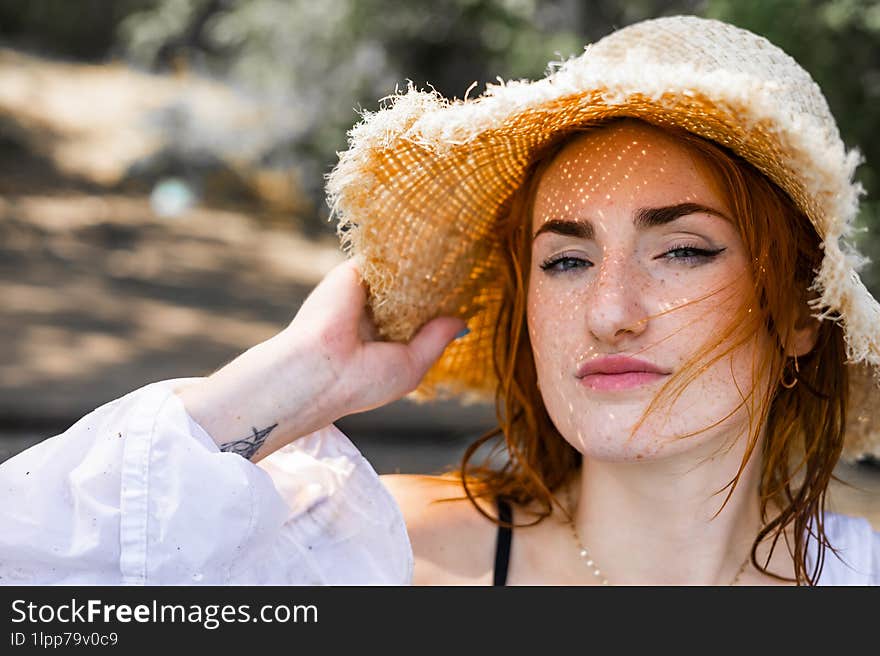 Red hair woman in swimsuit and summer hat near river.