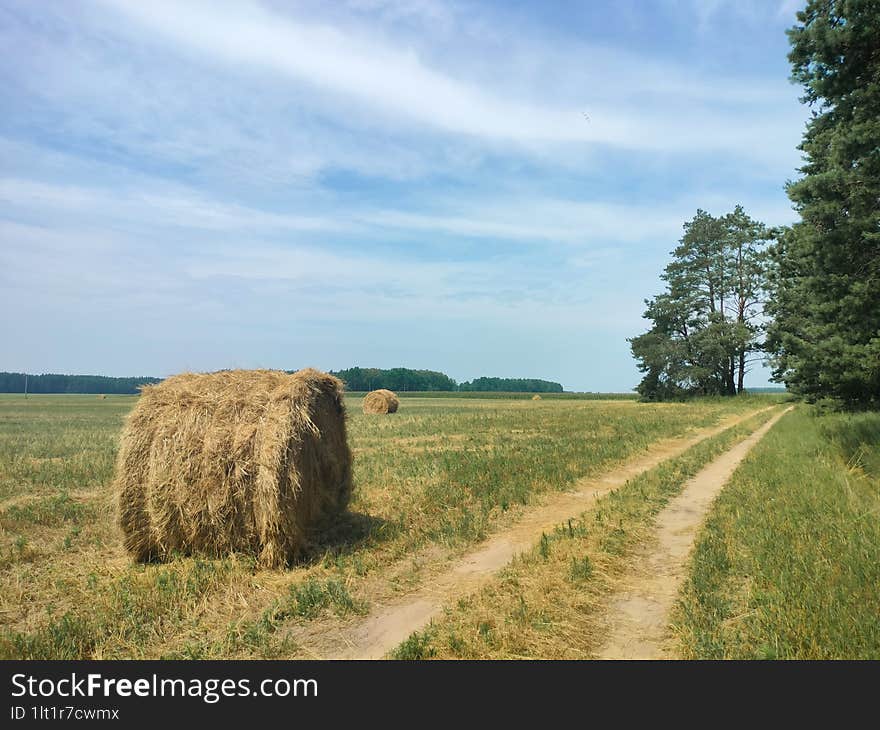 summer, road, straw stack on a mown field