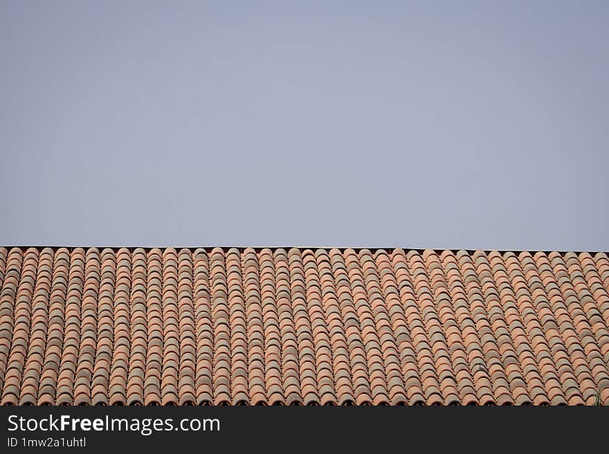 Close-up of a building�s terracotta roof tiles under an overcast sky, highlighting the architectural style and roofing materials