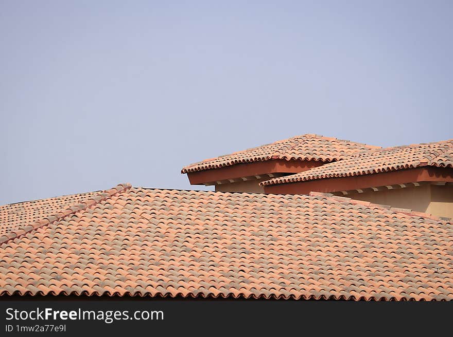 Close-up of a building�s terracotta roof tiles under an overcast sky, highlighting the architectural style and roofing materials