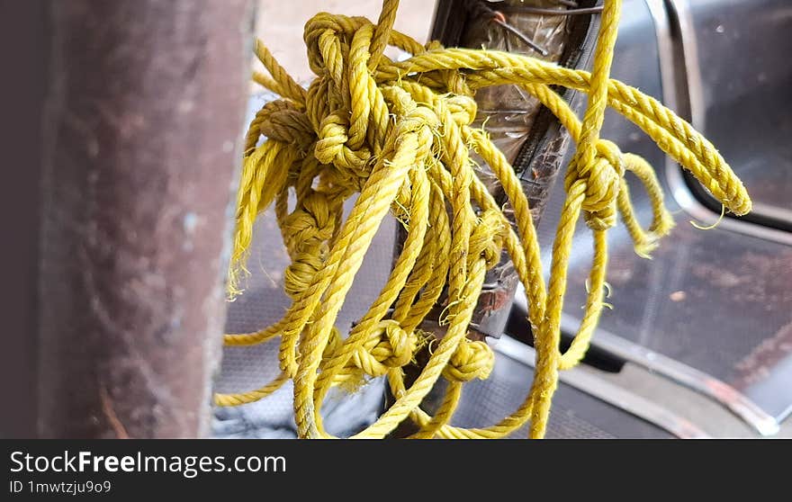 Close-up Of An Old Yellow Rope With A Messy Knot.