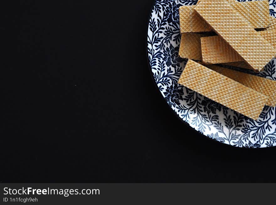 decorated plate with cookies on black background