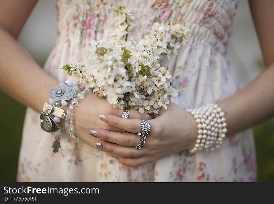 girl holds a branch of blossoming apricots in her hands. Close up of beautiful female hands holding a branch of blossoming fruit tree. delicate spring background. female hands on blurry background