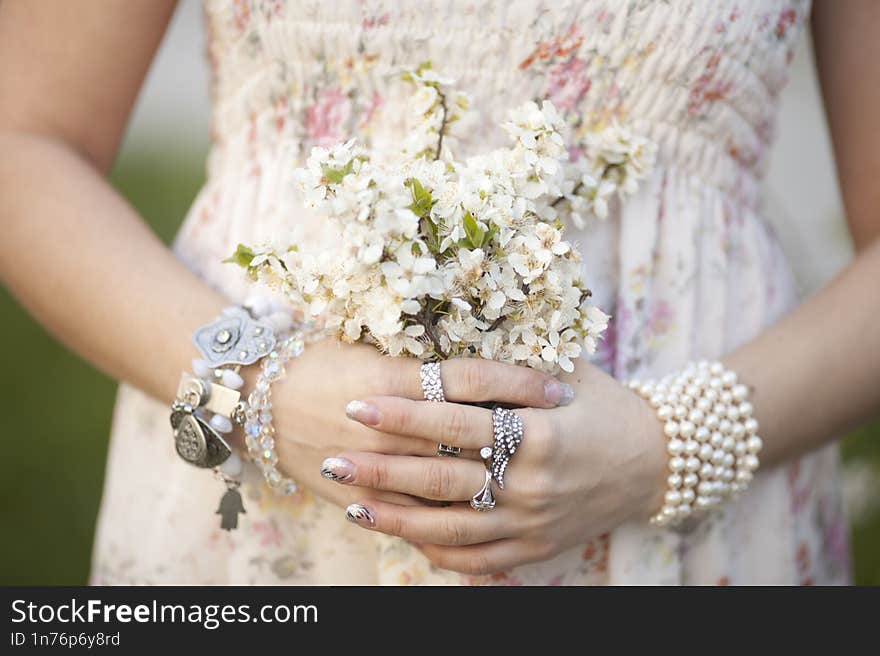 girl holds a branch of blossoming apricots in her hands. Close up of beautiful female hands holding a branch of blossoming fruit t