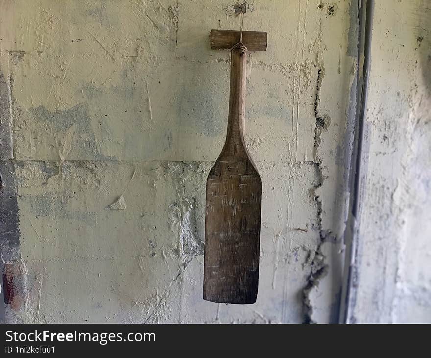 an antique wooden paddle attached to the wall