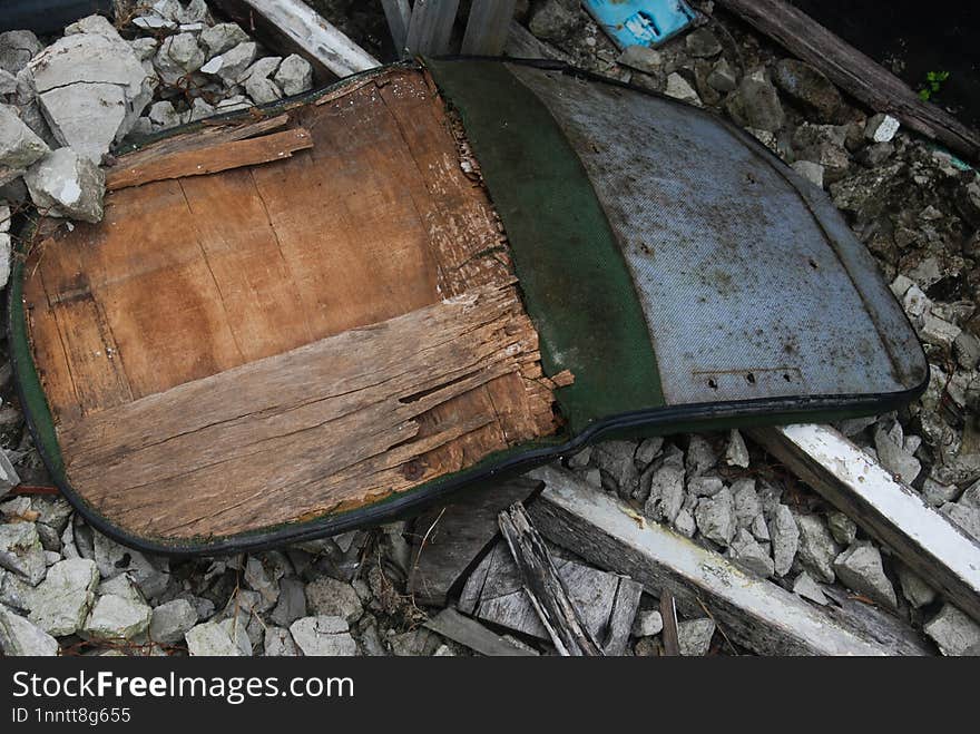 Lonely broken green chair inside an abandoned shabby room