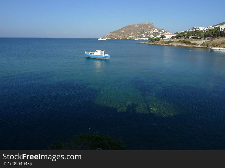 A small boat is anchored in clear turquoise waters