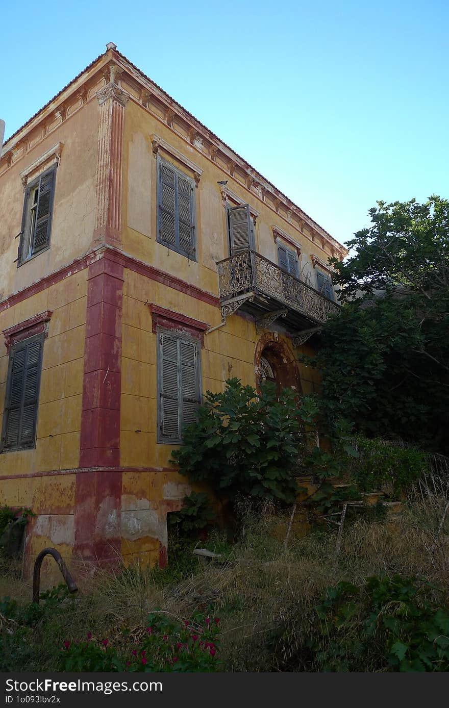 A two-story abandoned house claimed by nature