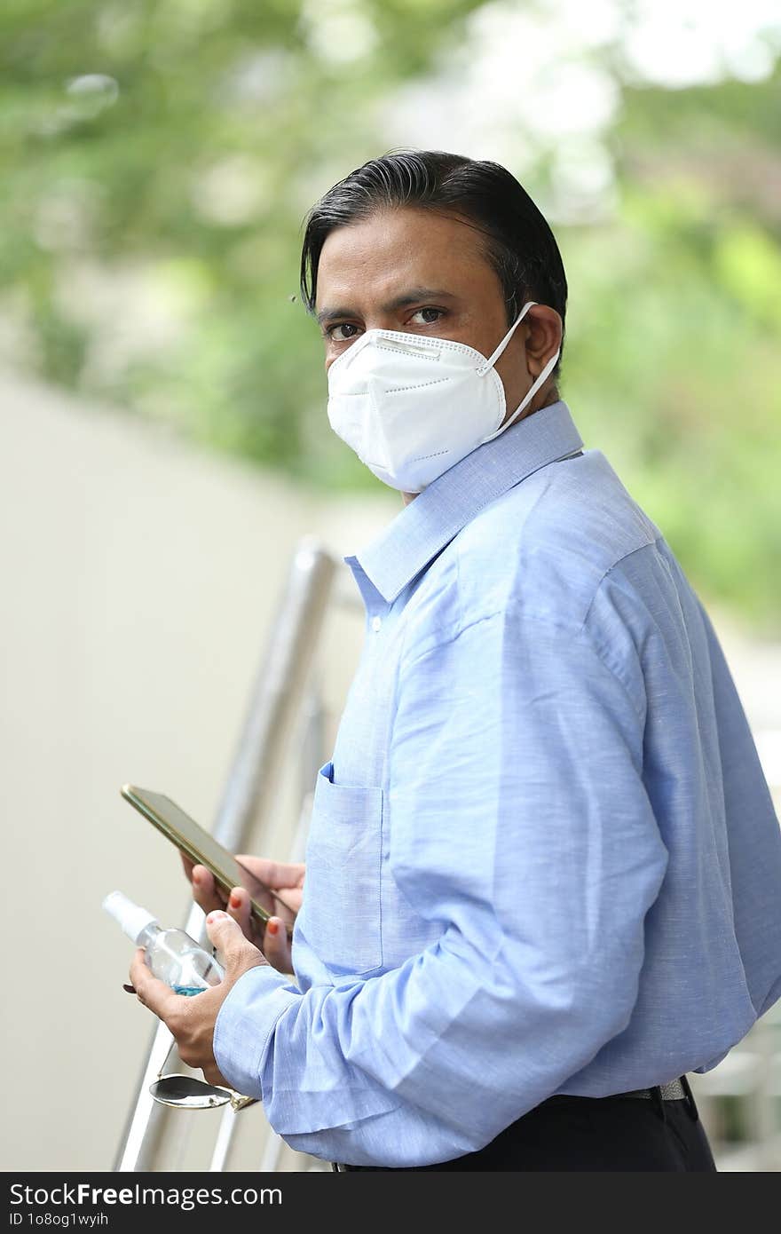 Young Indian confident businessman in mask standing outdoors. Corona warrior at work in India. Corona warriors doing work amid risk of Covid-19 pandemic. Helping the economy. Economy warriors.