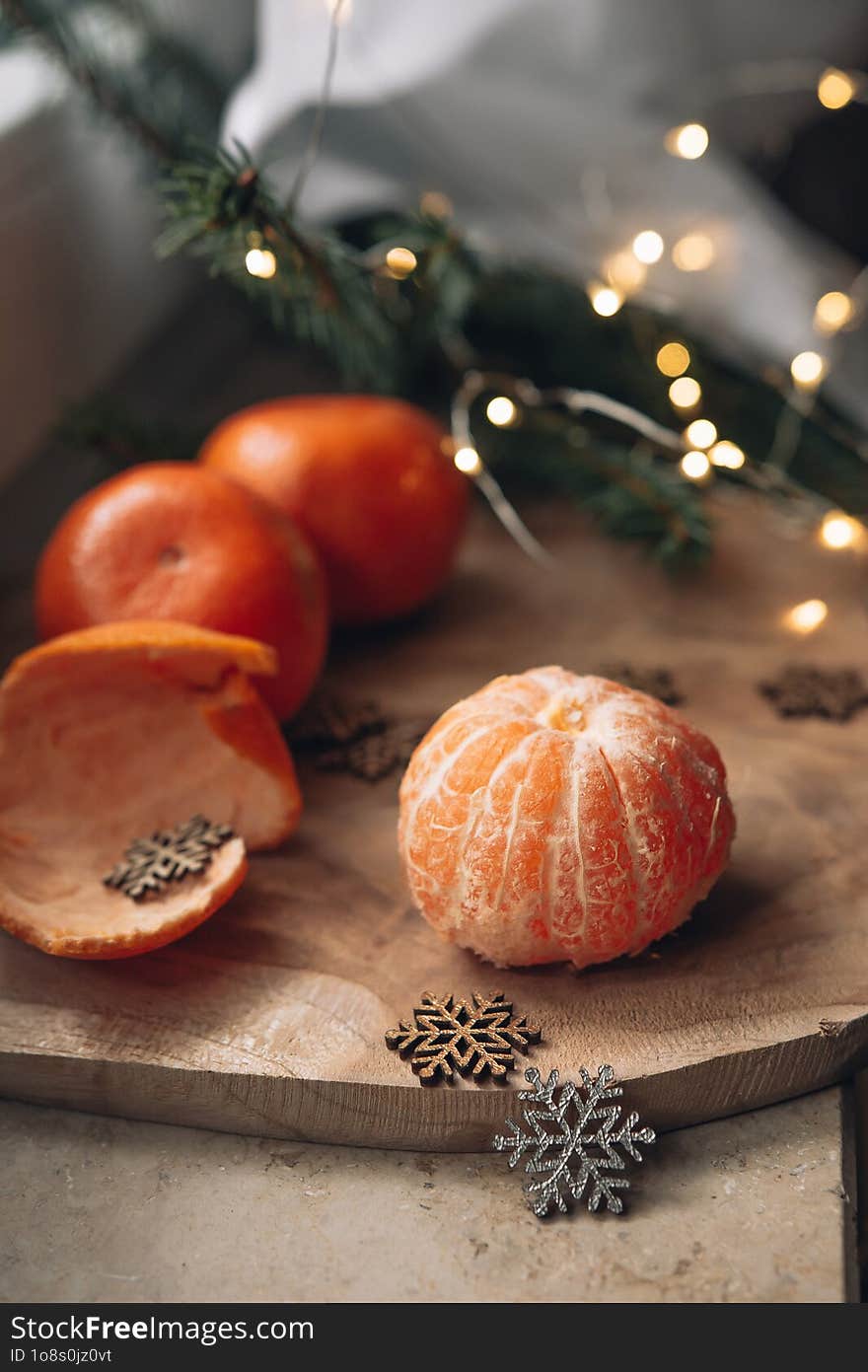 Christmas still life on a wooden background with tangerines, fir branches and snowflakes. Christmas card with place for text.