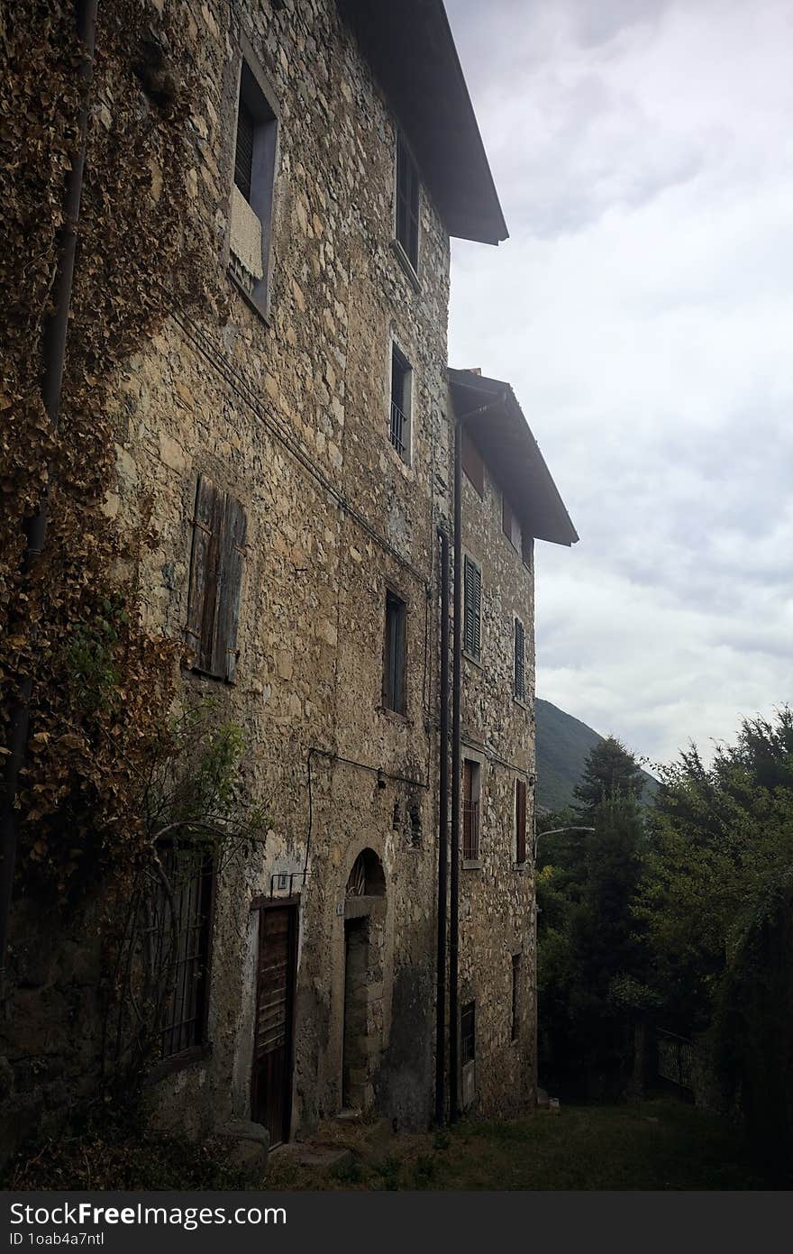 Sloppy cobbled path between a stone wall and a stone building in the mountains. Sloppy cobbled path between a stone wall and a stone building in the mountains