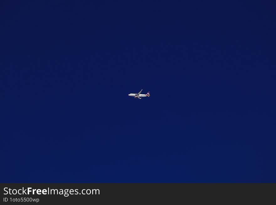 An airplane soars gracefully through a clear blue sky, representing freedom and adventure