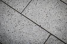 Close-up View Of A Terrazzo Floor Composed Of Light-colored Tiles With Dark Speckles, Divided By Thin, Dark Grout Lines Royalty Free Stock Photography