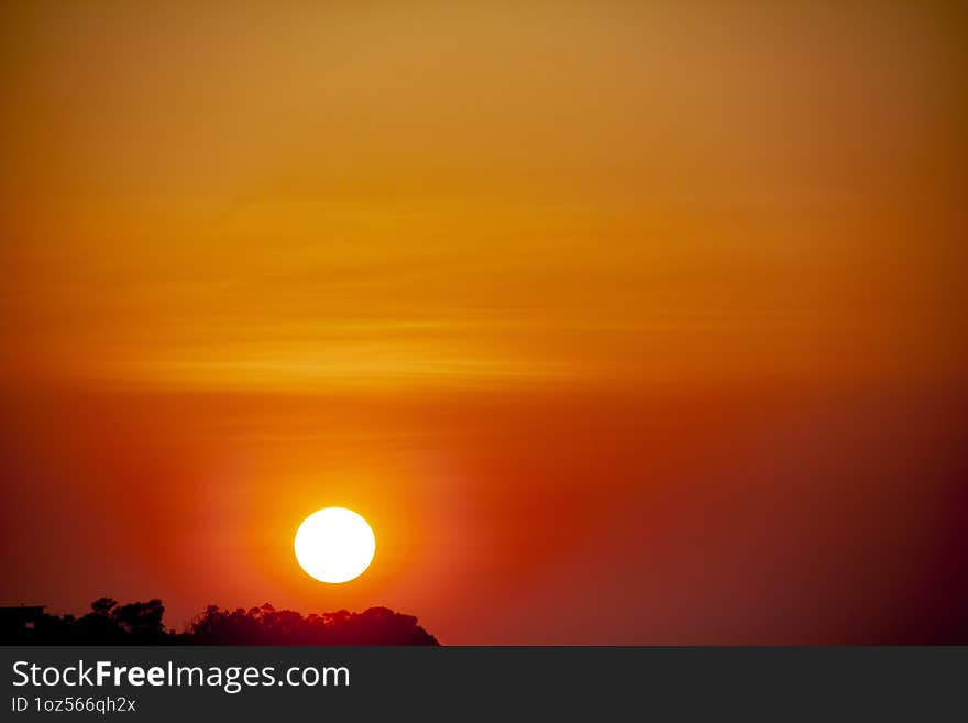 Orange and round sun close-up. Close-up of the orange and round sun at sunset with strong and light colors