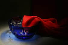 A Blue Vase With A Carved Flower Design Decorated With A Scarlet Light Scarf Flowing From It Stock Photography