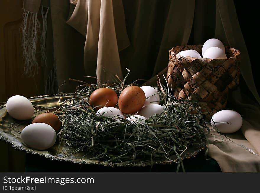 Chicken eggs lie in a nest of grass