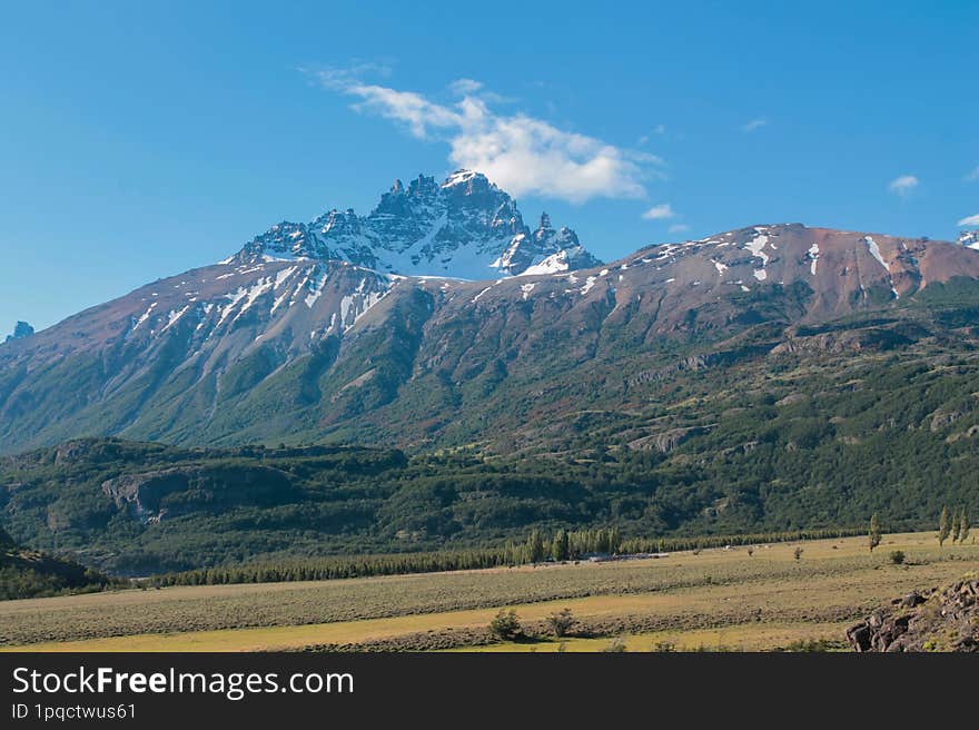 Cerro Castillo mountain in Patagonia, Chile. Mountain landscape with green meadow and blue sky in summer