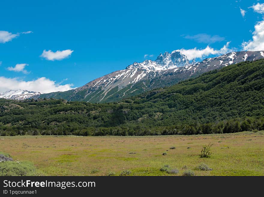 Cerro Castillo mountain in Patagonia, Chile. Mountain landscape with green meadow and blue sky in summer