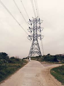 A Man Walking On Village Road In Summer Electrity Tower In Background Royalty Free Stock Photos