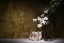 A Bouquet Of Snowberries Against An Unpainted Wall And Three Ceramic Fish Stock Photos