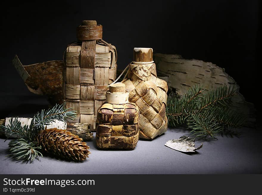 Birch bark products. Still life with souvenir wicker bottles. Handmade bottles